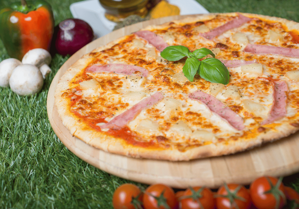 Safe home fireplace cooked pizza sitting in grass with ingredients pizza oven benefits blog image on safe home fireplace website