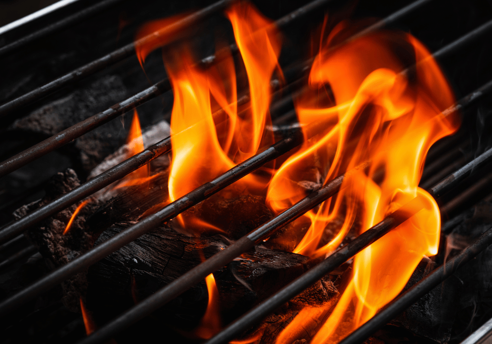 Safe home fireplace grill closeup with flames and wood charcoal barbecue guide blog image on safe home fireplace website